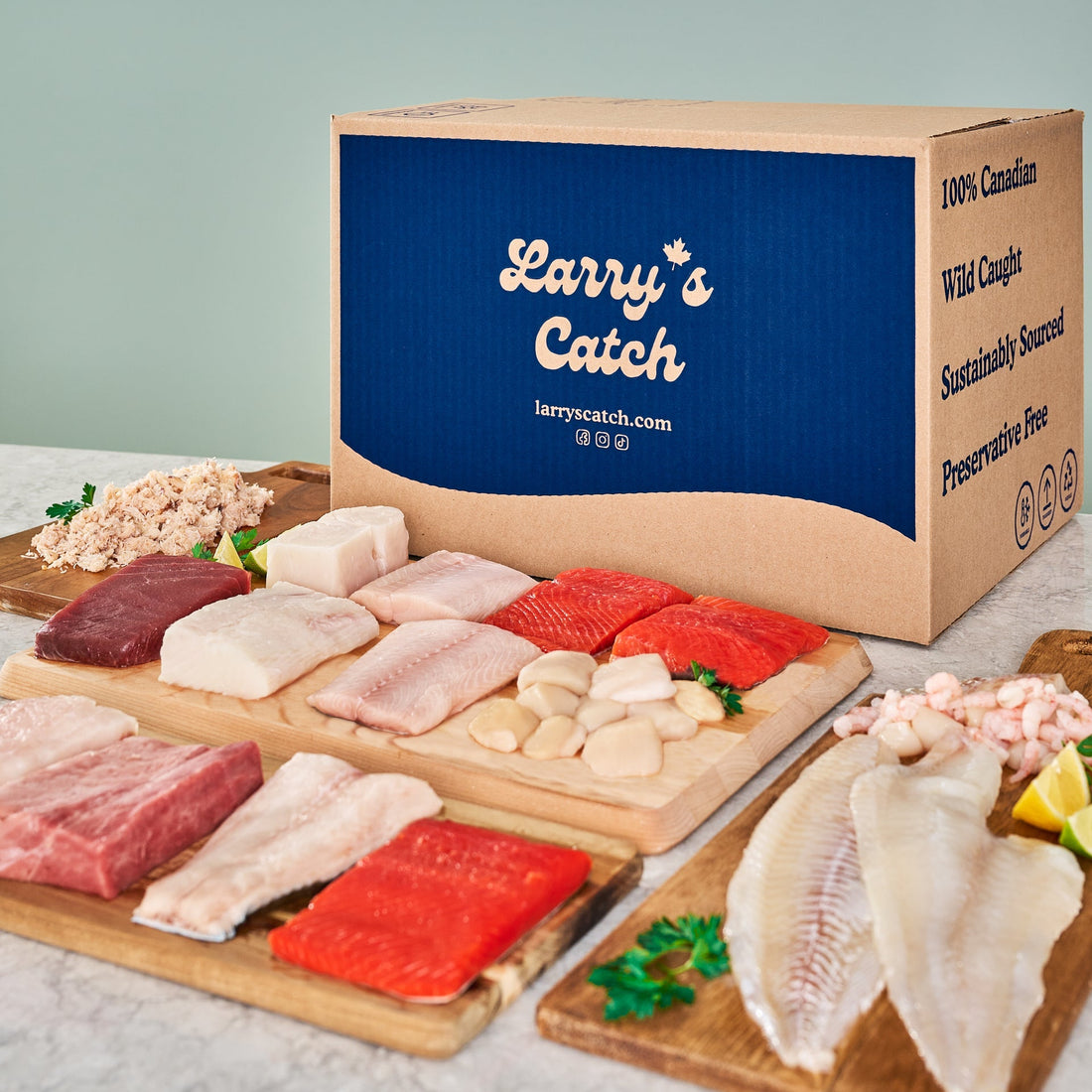 A delivery box labeled "Larry's Catch" is surrounded by cutting boards displaying various cuts of raw fish, seafood, and flakes.